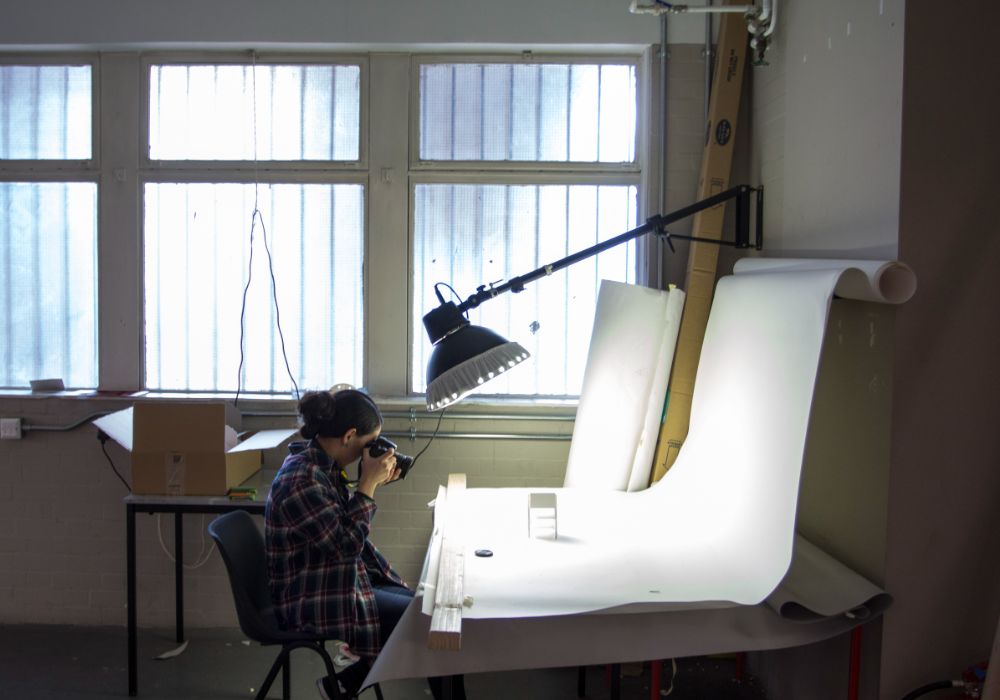 A person sitting at a desk, focused on a camera.