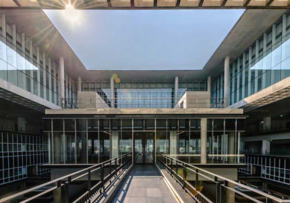 Sunlight streams through the glass walls of a modern building.