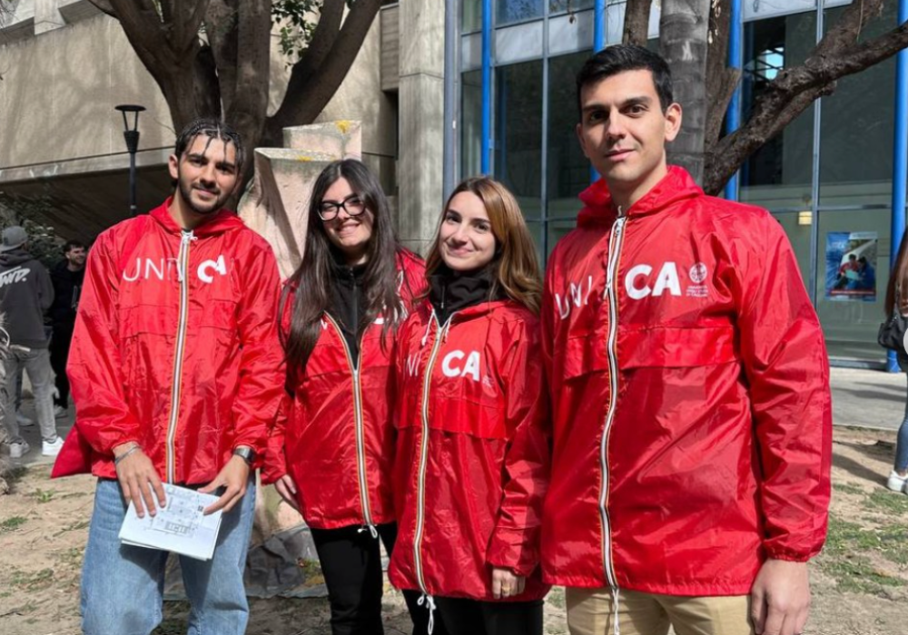 Students wearing red jackets standing closely together.